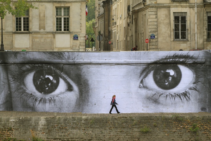 a large mural on the side of a building with eyes painted in black and white