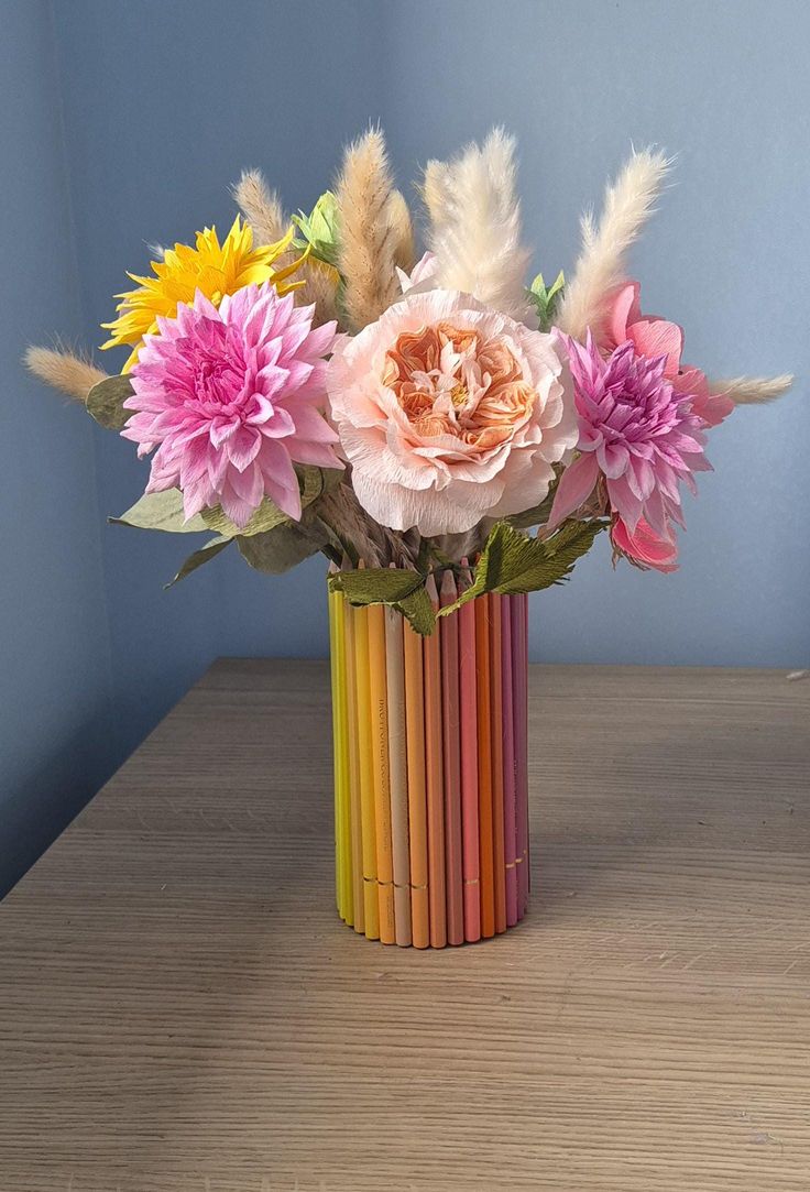 a vase filled with lots of different colored flowers