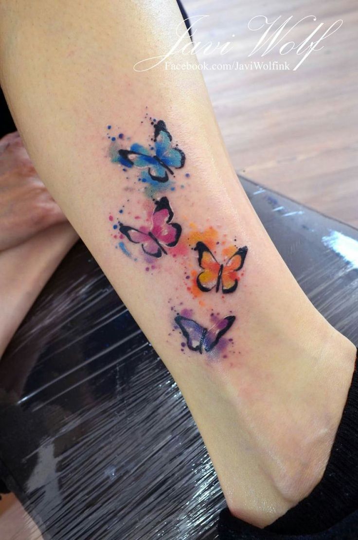 a woman's foot with watercolor butterflies on the left side of her leg