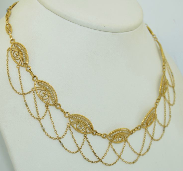 "This necklace is in absolutely fabulous condition. It is of French origin, crafted from 18 karat solid yellow gold. The Necklace features a completely hand crafted chain and very very fine goldsmith work on the plaques. There are seven plaques in total, each one with finely twisted gold rope and a finer twist in the center of each. The plaques feature 13 natural seed pearls. Each pearl is drilled and pinned and in fine condition. The swag is a double chain with a seed pearl at the base of each Ornate Yellow Gold Necklace For Formal Occasions, Gold-plated Necklaces For Evening, Gold Custom Necklace With 17 Jewels For Formal Occasions, Exquisite Gold Necklace For Formal Occasions, Formal Custom Gold-plated Necklace, 14k Gold Filigree Necklace For Formal Occasions, Ornate Formal Jewelry With Chain, Luxury 14k Gold Necklace With Intricate Design, Formal 14k Gold Necklace With Intricate Design