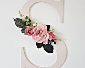 the number nine is decorated with pink flowers and greenery on it's side