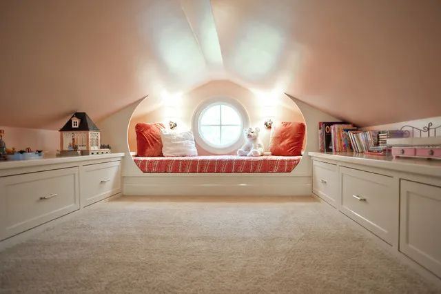 an attic bedroom with built in bookshelves and windows