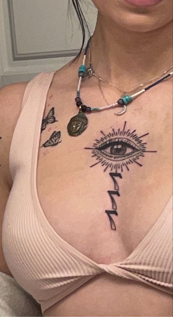 a woman with an all seeing tattoo on her chest