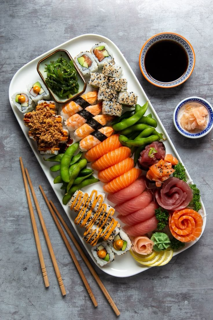 sushi platter with chopsticks and sauce on the side next to it