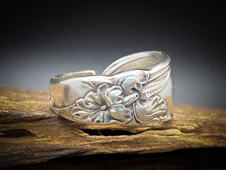 "The \"White Orchid\" has a simple curl and leaf adorning its round spoon top. But mid-way down the handle lays a boastful orchid that will bloom always for you. This is an elegant and hefty piece. This ring is made-to-order, unique and especially for you. Be sure to see my other rings designs available. I also make bracelets and necklaces from these patterns. Please feel free to contact me about special orders made from my collection or yours." Orchid Ring, Vintage Spoon Rings, Saddle Ring, Antique Silverware, Spoon Ring, Vintage Silverware, Spoon Rings, White Orchids, Saint George