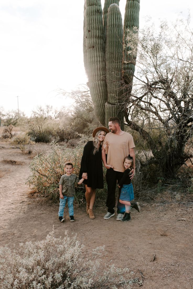 a family standing in front of a large cactus