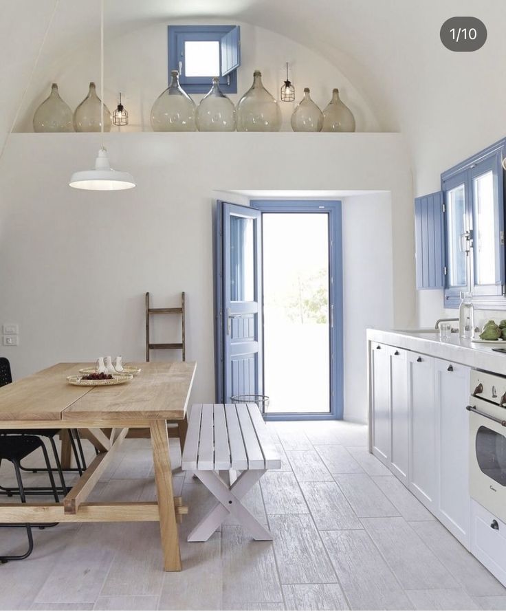 a kitchen with an oven, table and chairs next to a door that leads to another room