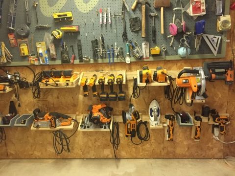 tools are hanging on the wall in a workshop