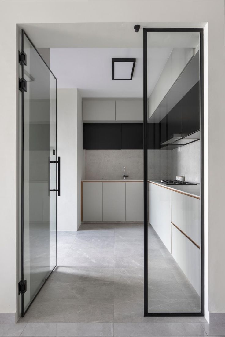 an empty kitchen with glass doors leading into the room