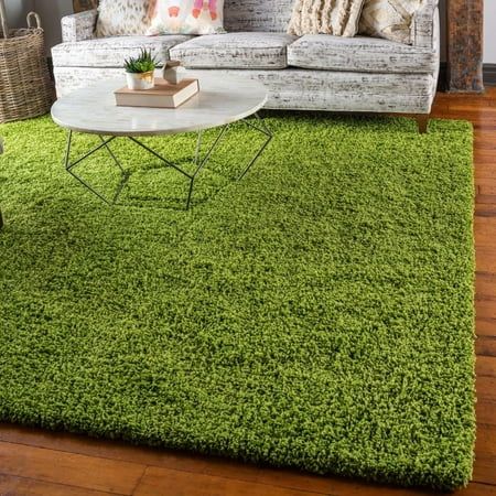 a living room filled with furniture and green rugs