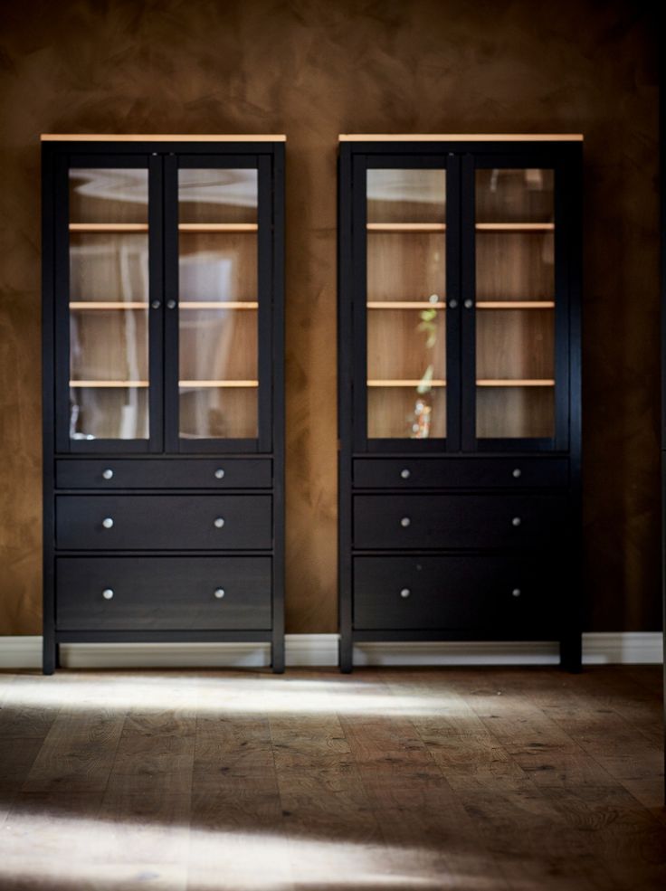 an empty room with two tall black cabinets