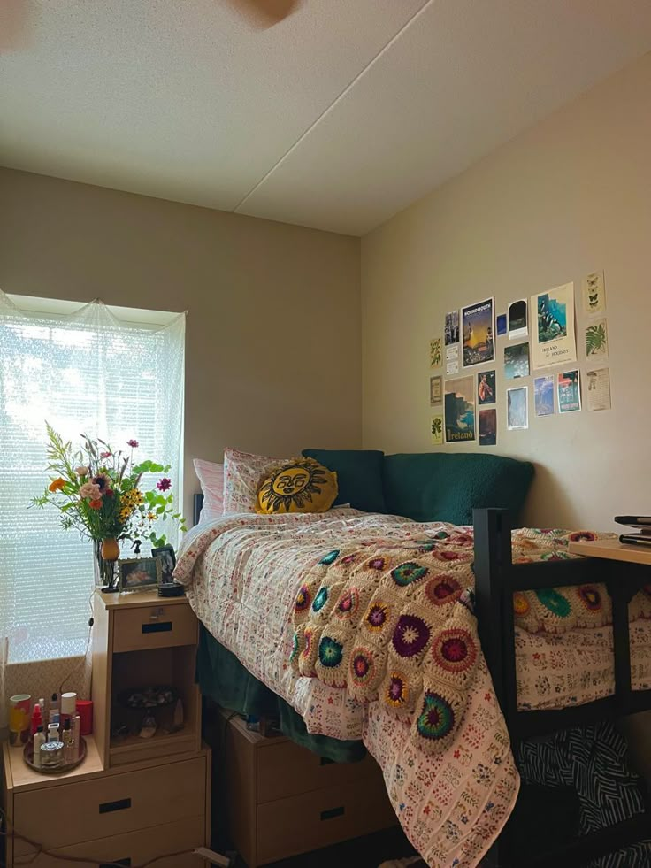 a bedroom with a bed, dresser and window in the corner next to a plant