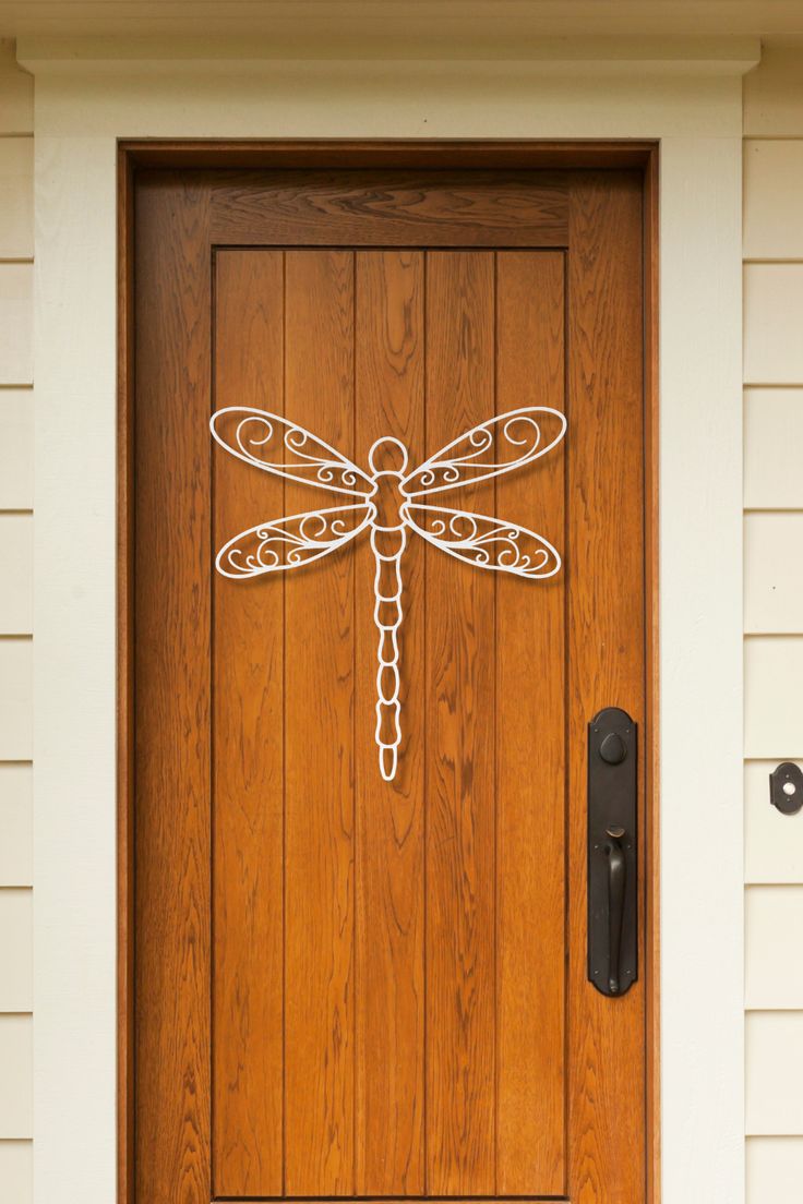 a wooden door with a metal dragon on it's side and a black handle