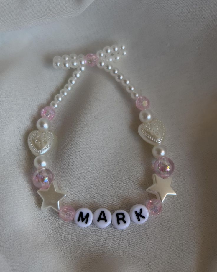 the name mark is written on a beaded bracelet with stars and hearts in white