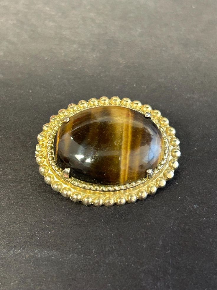 Beautiful! Vintage large Tigers Eye cabochon gold tone brooch. Gold Vintage Cabochons, Vintage Oval Gold Cabochons, Classic Gold Cabochons For Gifts, Antique Gold Brooches With Oval Cabochon, Antique Gold Oval Cabochon Brooches, Antique Gold Brooch With Oval Cabochon, Antique Gold Oval Cabochon Brooch, Classic Gold Round Brooches, Gold Round Brooch Pins