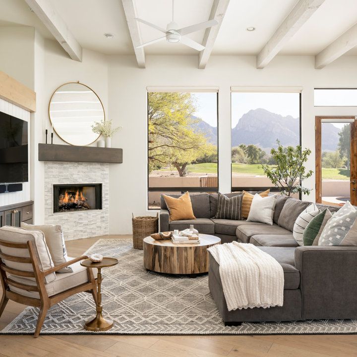 a living room filled with furniture and a fire place in front of a large window