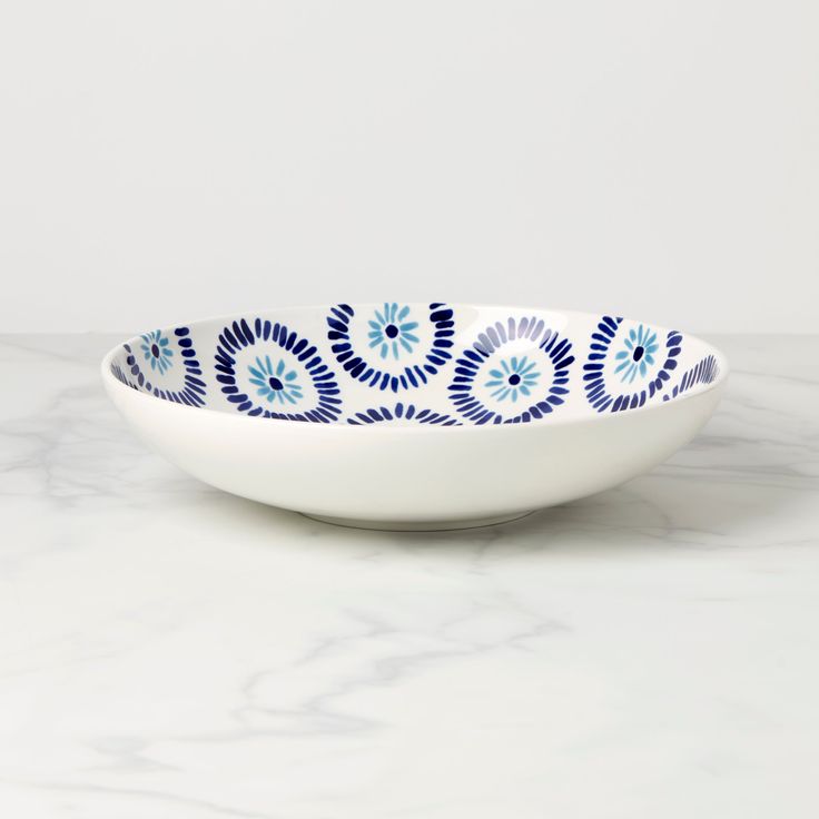 a blue and white bowl sitting on top of a marble counter