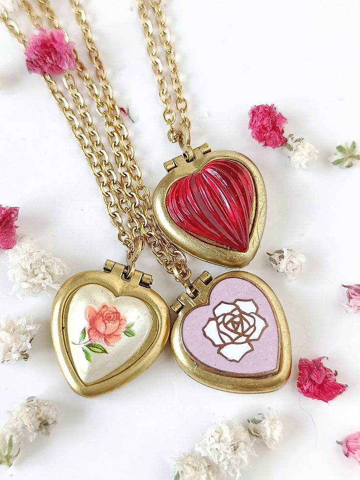 "♥️ Unused 50s vintage tiny heart lockets. They measure 15mm x 14mm and are the same except for cover decoration. They have space for adding a picture inside one of the lids. These lockets are made of brass. Hinges and closures all in good working condition.  Some of them have small stains or patina due to the passage of time as they are quite old. They look beautiful, just showing their age.  1. PINK COPPER ROSE: with a 60s copper and enamel rose.  2. RUST ROSE: stamped on Japanese porcelain heart.  3. *RED: little pearlized puffed glass heart. I have a few vintage locket necklaces in the same patterns. All of them are vintage and aren't produced nowadays.  CHAIN OPTIONS: 1. 24K GOLD PLATED CHAIN: (doesn't tarnish or stain): 16.4\" = 40cm or 20\"  = 50cm   If you have any questions, feel Vintage Heart Pendant Charm Necklace For Mother's Day, Vintage Heart Pendant Charm Necklaces For Mother's Day, Vintage Locket Charm Necklace For Mother's Day, Vintage Personalized Heart Charm Necklaces, Personalized Vintage Heart Charm Necklaces, Personalized Heart-shaped Vintage Charm Necklaces, Personalized Heart-shaped Vintage Charm Necklace, Vintage Heart Charm Locket Necklace As A Gift, Vintage Locket Necklace With Heart Charm For Gifting