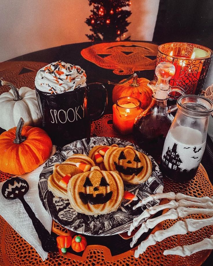 a table topped with halloween cookies and candles