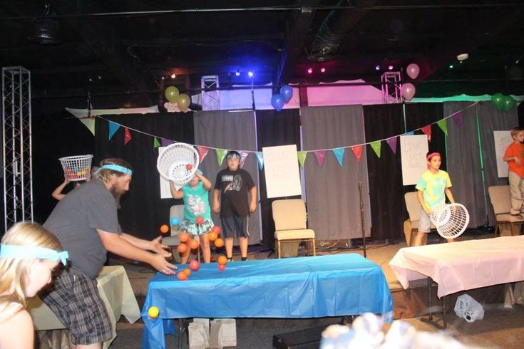 a group of people standing on top of a stage next to a blue cloth covered table