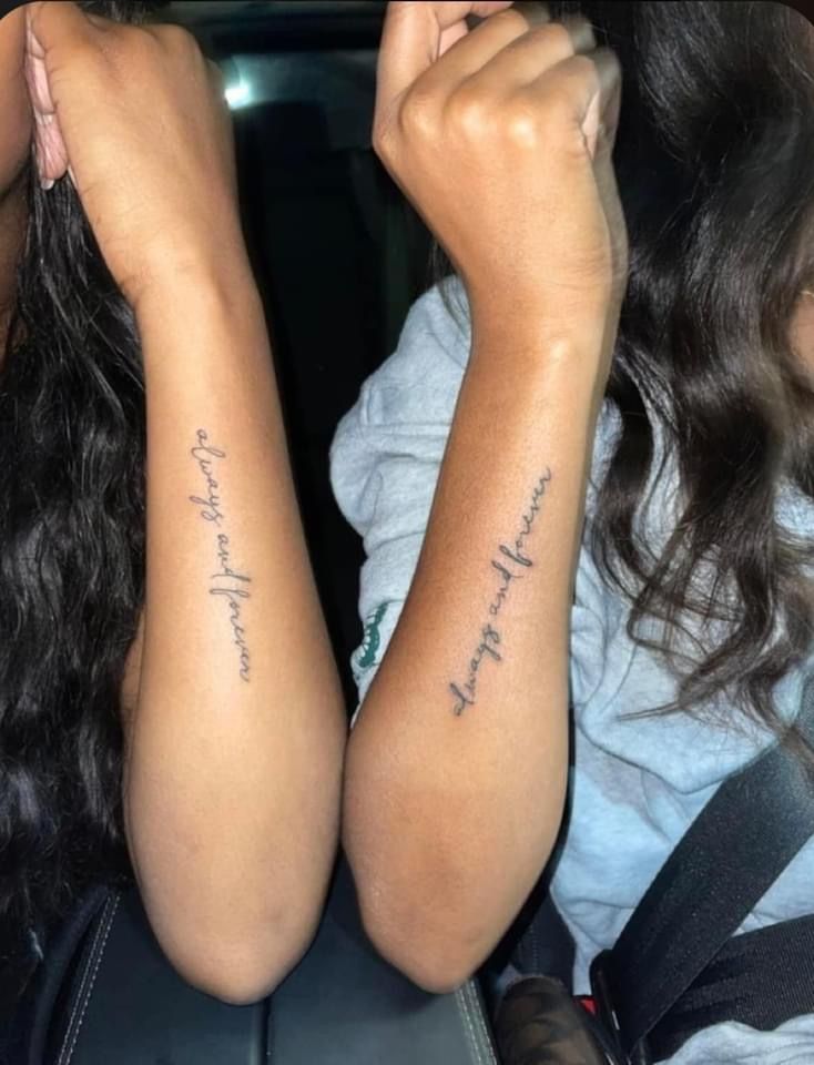 two women sitting in the back seat of a car with their arm tattoos on them