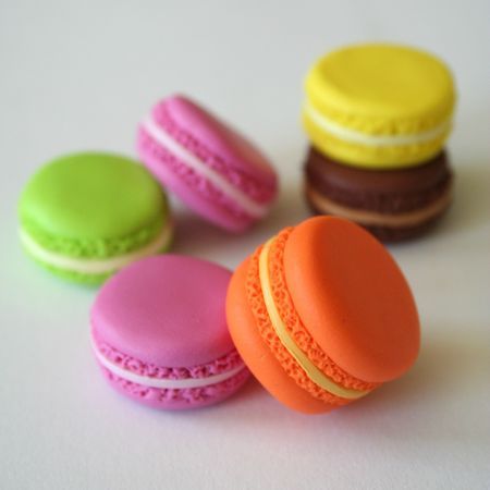 small macaroons are lined up on the table, with one cookie in the foreground