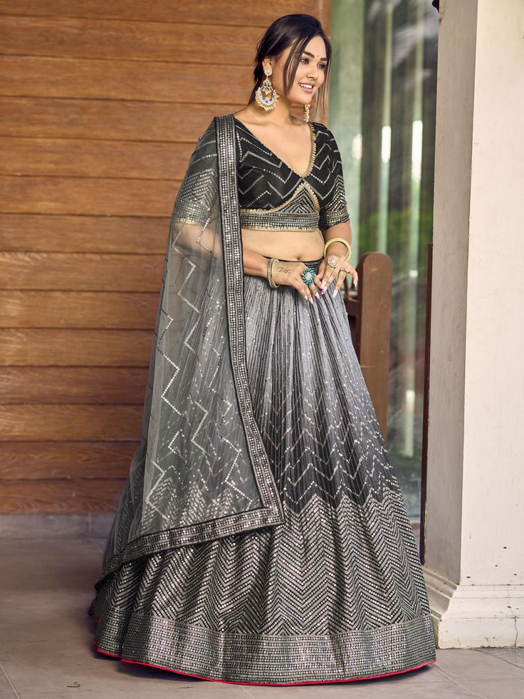 Add elegance and sophistication to your ethnic wardrobe with our fabulous black sequins chinon reception wears lehenga choli. This stunning ensemble includes a black color chinon material lehenga with intricate thread embroidered work and sequin detailing, complemented by a similar color chinon choli featuring matching embroidery and sequin work. The look is completed with a light grey net dupatta adorned with sequin work and a captivating lace border.
This outfit includes its semi-stitched blac Black Choli With Intricate Embroidery In Georgette, Black Traditional Wear With Sequins, Black Floor-length Party Wear Sets, Black Embroidered Anarkali Set For Party, Embroidered Black Anarkali Party Wear Set, Black Floor-length Lehenga With Intricate Embroidery, Floor-length Black Lehenga With Intricate Embroidery, Embroidered Black Anarkali Set For Party, Black Sharara With Intricate Embroidery For Navratri