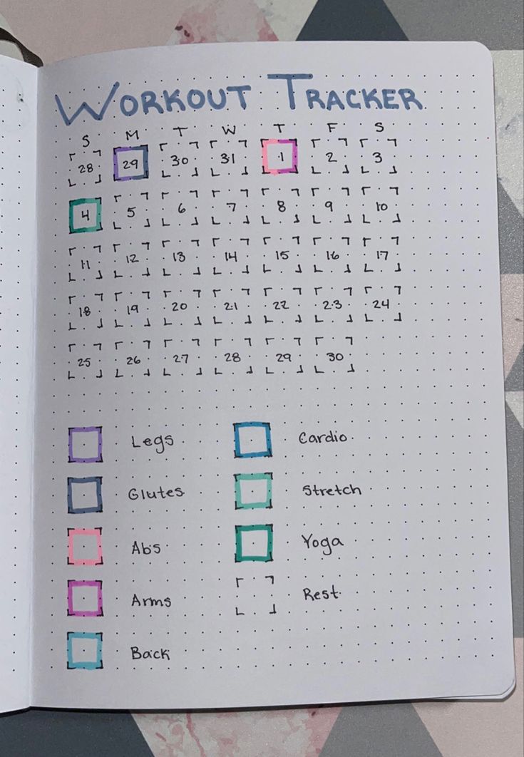 an open notebook with the words workout tracker written in blue and green on top of it