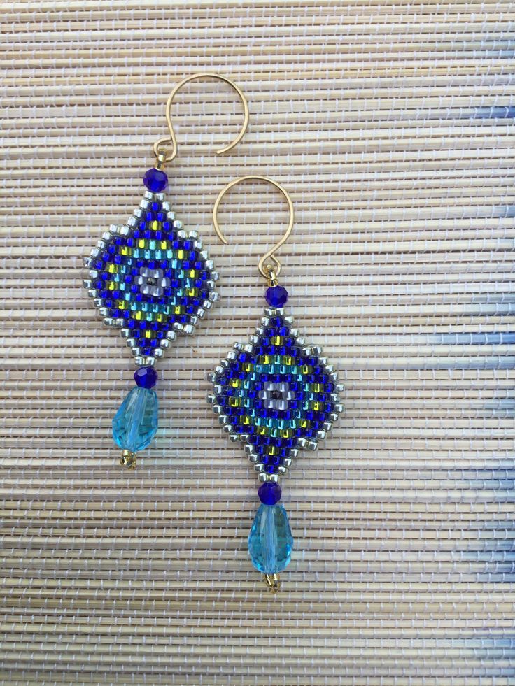 Inspired by ancient Egyptian jewellery, these earrings combine the colours of the stones the Egyptians loved in the classic hexagon shaped. Topped and tipped with blue, faceted glass orbs and a teardrop. Finished with gold-lined beads and acented with pale golden. Created out of Japanese glass beads. Hung on stainless steel ear wires. Bohemian Crystal Earrings With Faceted Beads For Gift, Handmade Czech Glass Drop Earrings, Bohemian Dangle Earrings With Faceted Details, Turquoise Teardrop Earrings With Faceted Beads, Czech Glass Teardrop Faceted Beads Jewelry, Teardrop Czech Glass Faceted Beads Jewelry, Teardrop Czech Glass Jewelry With Faceted Beads, Artisan Blue Drop Earrings, Beaded Czech Glass Teardrop Earrings