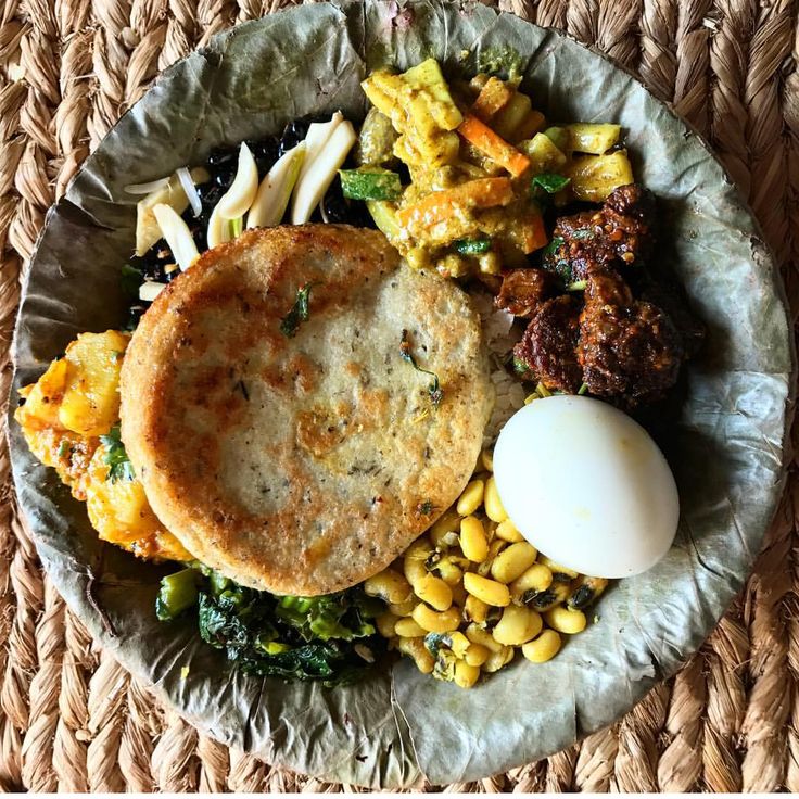 a plate with some food on it and an egg in the middle next to other foods