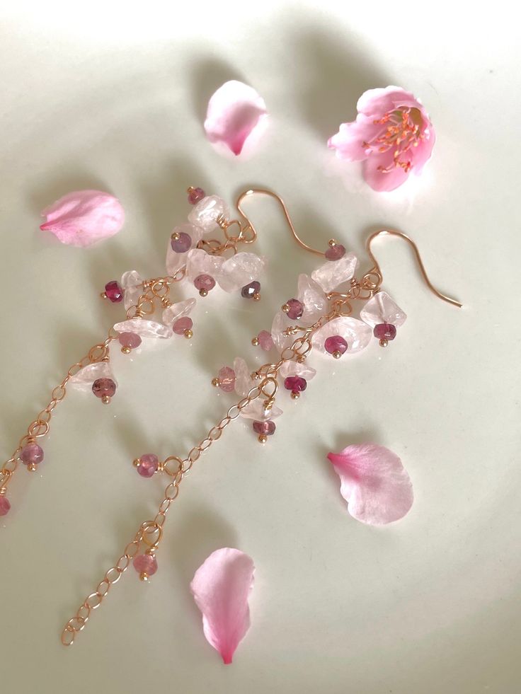 "There are many types of pink blossoms, but the pink cherry blossom - called 'sakura' in Japanese - are some of the most breathtaking. I've added tiny little faceted rondelles of various shades of pink tourmaline, from rubellite to soft pink, and nestled them into smooth chips of rose quartz on 14K rose gold-filled chain and findings, to give that impression of the delicate pink blossoms with dark pink centers. The Sakura earrings are 3.25\" in length, from rose gold-filled earhooks. You can cus Pink Flower Crystal Earrings, Pink Elegant Flower Earrings For Valentine's Day, Elegant Pink Flower Earrings For Valentine's Day, Pink Flower-shaped Earrings For Valentine's Day, Pink Flower Crystal Earrings For Gift, Dainty Pink Flower-shaped Jewelry, Delicate Pink Flower Jewelry, Dainty Pink Flower Jewelry, Pink Crystal Round Earrings For Gift