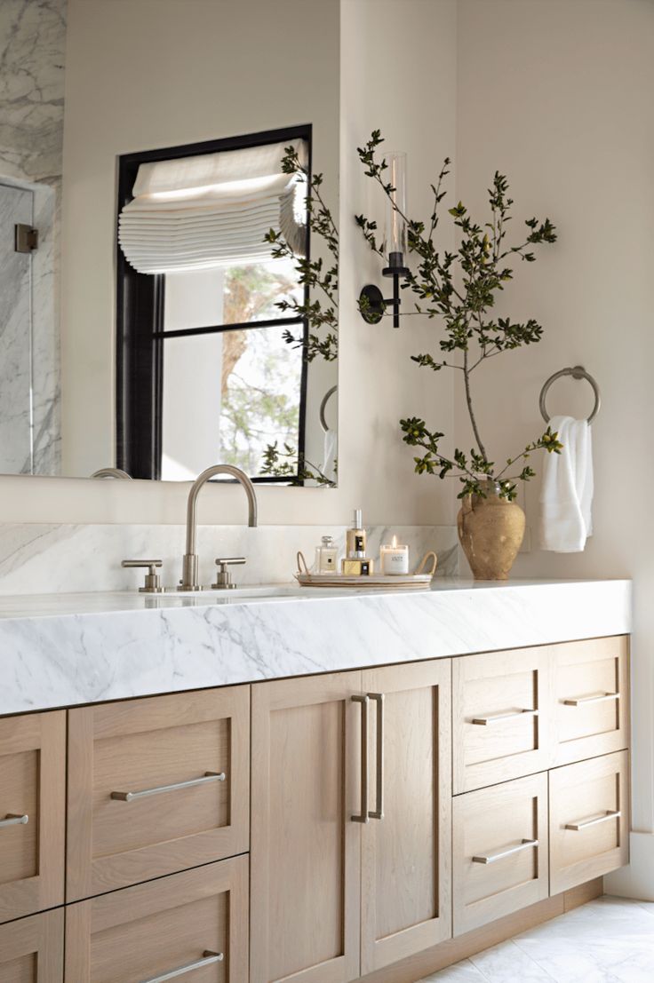 a bathroom with marble counter tops and wooden cabinets