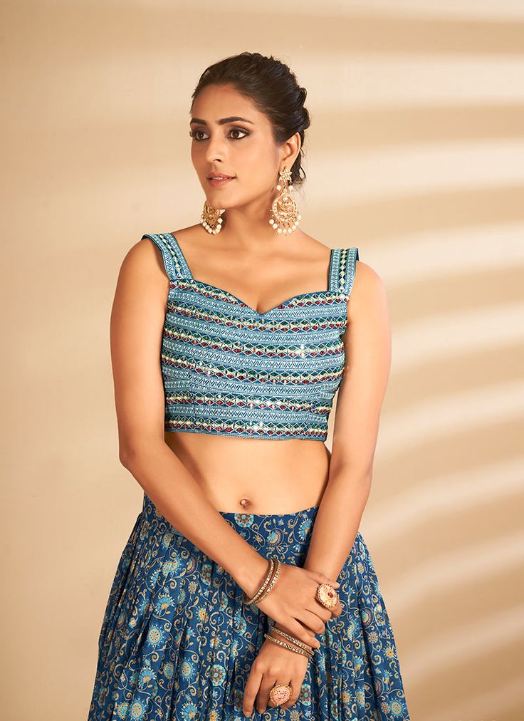 Blue Multi Embroidered Traditional Lehenga Choli will make you look like a diva with its traditional style and beautiful embroidery annotated perfectly with zari, resham thread and badla mirror work on its art silk choli top paired with multicoloured digital printed art silk lehenga. The beauty part of this lehenga is its minimalist soft net latkan embellished dupatta. Style this pretty attire on any wedding or festive party with heels and jewellery to look stunningly beautiful from the rest of Bollywood Style Multicolor Embroidered Sequin Sets, Festive Multicolor Embroidered Sequined Choli, Bollywood Style Lehenga With Multicolor Embroidery And Sequins, Bollywood Style Choli With Multicolor Embroidery And Sequins, Bollywood Sequined Lehenga With Multicolor Embroidery, Traditional Blue Sequin Choli, Festive Fitted Choli With Multicolor Embroidery, Festive Multicolor Embroidered Fitted Choli, Festive Fitted Multicolor Embroidered Choli