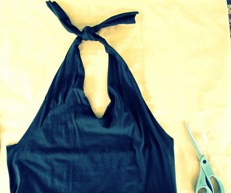 a pair of scissors sitting on top of a table next to a black halter top