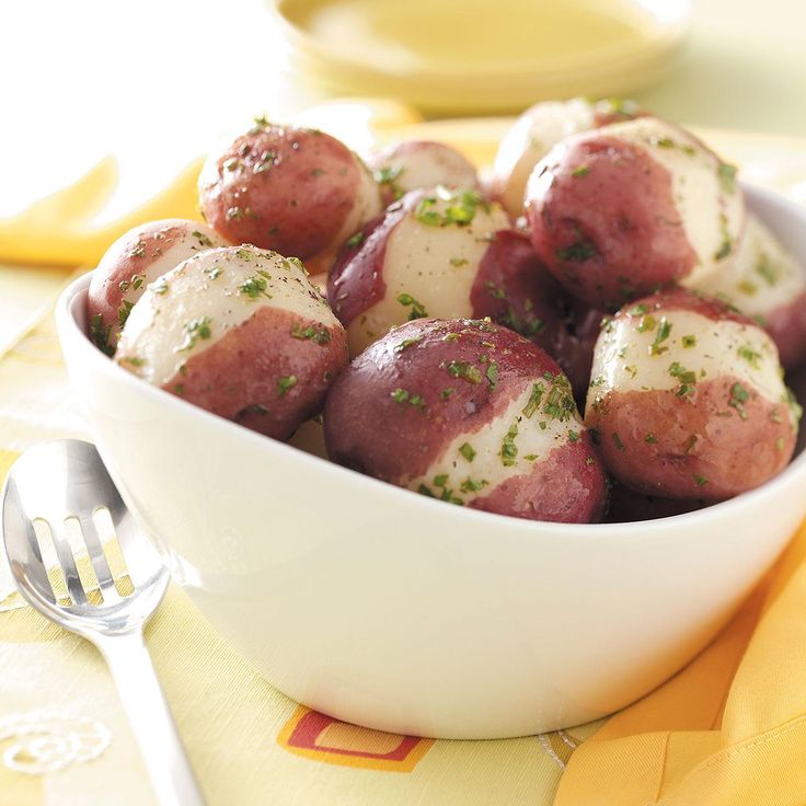 a white bowl filled with red and white food on top of a yellow table cloth