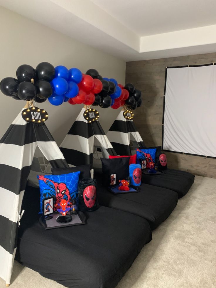 spiderman birthday party decorations and balloons in the shape of teepee cones with black and white stripes