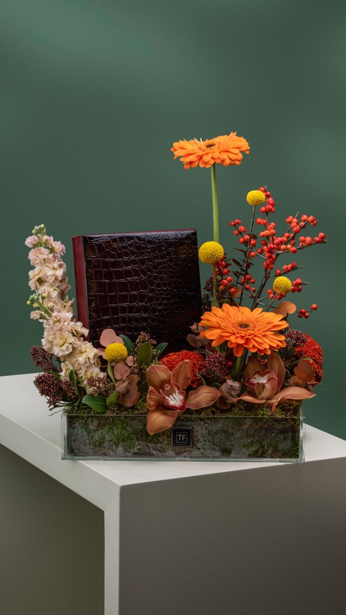 an arrangement of flowers is displayed on a table