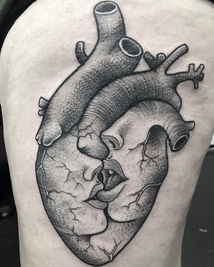 a black and white heart tattoo on the thigh