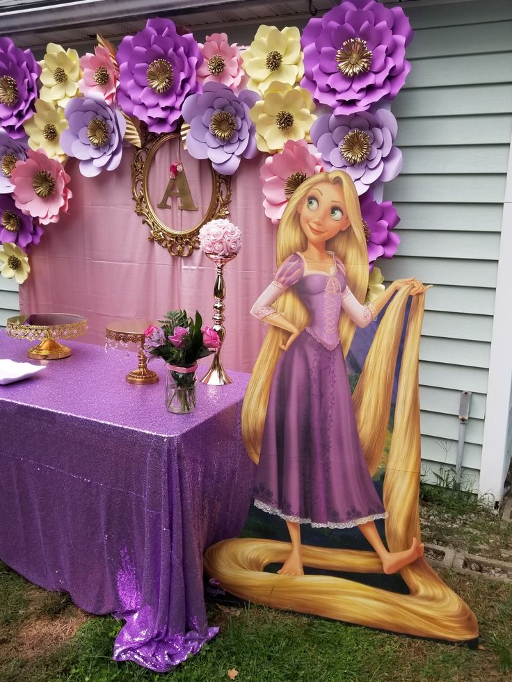 there is a table with paper flowers on it and a princess in purple dress next to the table