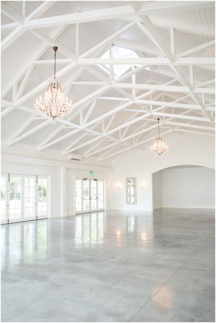 an empty room with chandeliers hanging from the ceiling