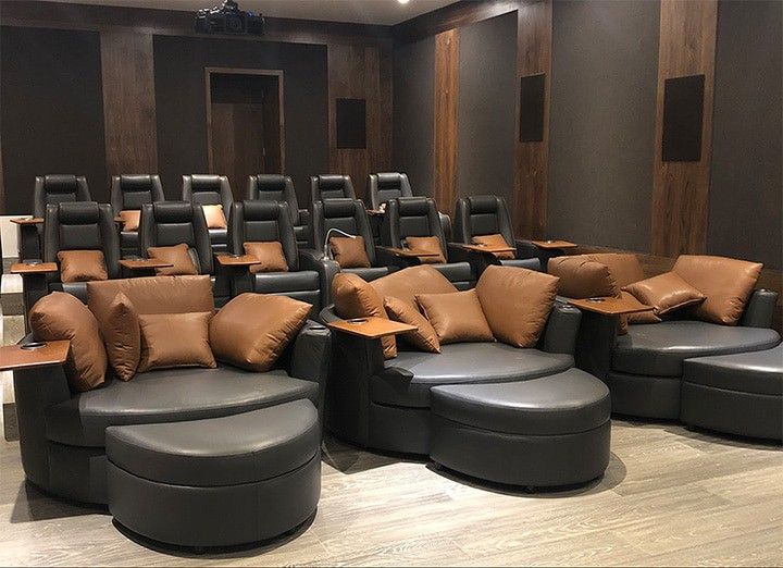 an empty theater with black leather seats and brown pillows