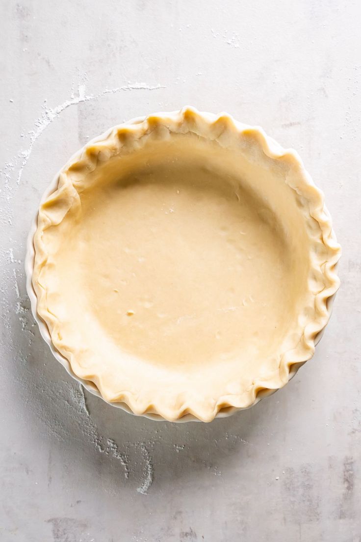 an uncooked pie crust on a white surface