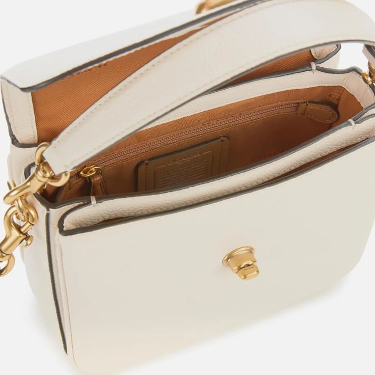 Make an elegant statement with the ‘Cassie’ cross body bag, by creator of luxurious leather goods, Coach. Fully-structured, the bag comes with a detachable strap that allows the wearer to carry the bag by hand, secured with gold-toned dog clips. A detachable over-the-shoulder strap is included, complementing the gold-hued branded hardware on the envelope-style flap and the eye-catching leather label attachment at the side of the bag. Opening the bag reveals a spacious inside, featuring a convenient zip-fastening pocket for essentials and supple branded lining. Finished with turn-lock closure. Leather Dimensions: H: 16.5cm x W: 19.9cm x D: 8.5cm. Strap Drop: 54cm. Coach Crossbody Satchel With Adjustable Strap, Coach Top Handle Satchel With Adjustable Strap, Coach Pebbled Leather Shoulder Bag With Detachable Strap, Coach Pebbled Leather Satchel With Detachable Strap, Formal Crossbody Satchel With Removable Pouch, Formal Satchel Saddle Bag With Detachable Handle, Formal Crossbody Shoulder Bag, Leather Crossbody Satchel With Metal Hardware, Formal Crossbody Satchel With Metal Hardware