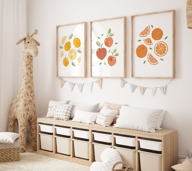 a white room with three pictures hanging on the wall and two stuffed giraffes