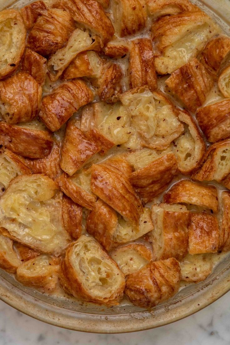 a dish filled with croissants sitting on top of a table