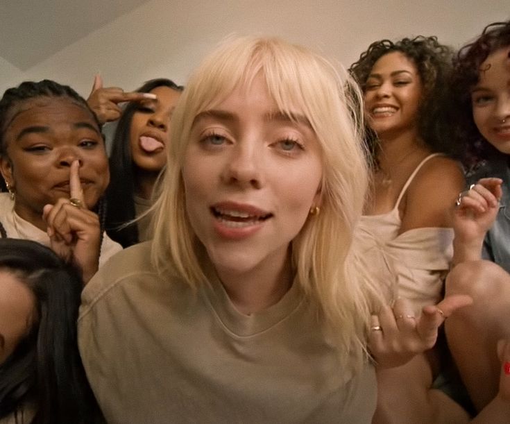 a group of women standing next to each other in front of a wall with their fingers up