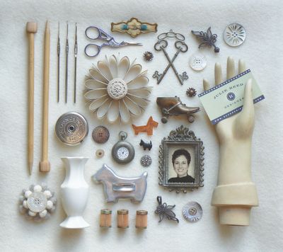 an assortment of items are displayed on a white tablecloth, including a mannequin's hand