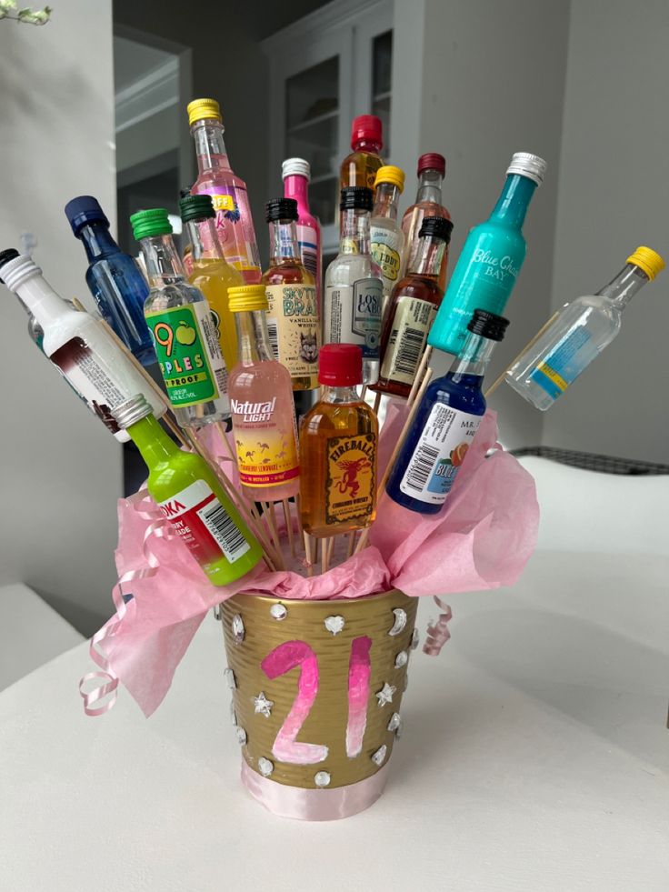 a cup filled with lots of different types of alcohol and condiments on top of a table