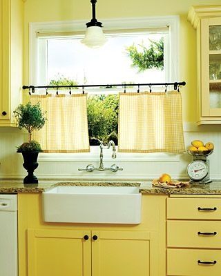 a kitchen with yellow cabinets and white appliances, including a dishwasher in the center