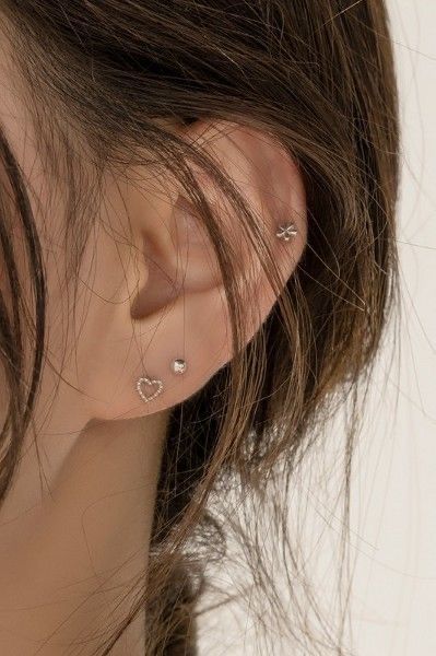 a close up of a person's ear with two piercings on it and one behind the ear